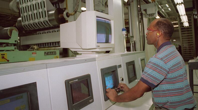 An employee at a metro Atlanta factory of RockTenn, now called WestRock after a 2015 merger, adjusts a printing operation in this 2004 photo. WestRock said Monday that it is selling its health and beauty-related business for $1 billion. (AJC Staff Photo/Laura Noel)