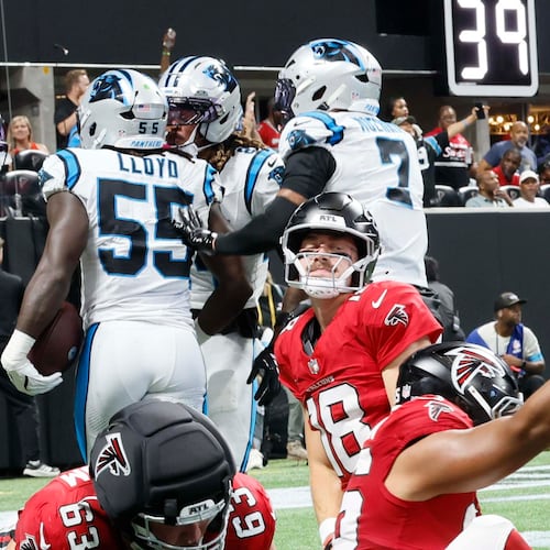 Atlanta Falcons quarterback Jack Strand (18), center, kneeling as the Carolina Panthers celebrate a touchdown after a fumble recovery during the second half of an NFL game at Mercedes-Benz Stadium in Atlanta on Sunday, Sept. 20, 2026. (Miguel Martinez/AJC)