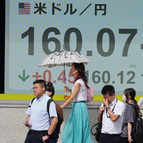 People stand in front of the electronic board showing Japanese Yen and U.S. Dollar exchange rate at a securities firm Friday, July 31, 2026. (AP Photo/Eugene Hoshiko)