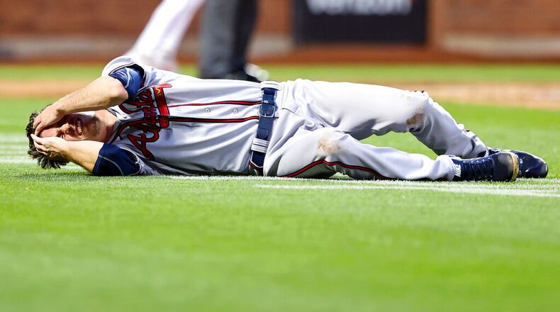 Atlanta Braves starting pitcher Max Fried lies on the ground during the third inning. Fried slammed the ground while chasing an errant throw but stayed in the game. (AP Photo/Jessie Alcheh)