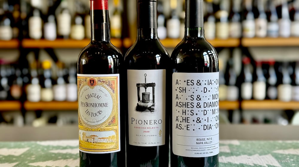 Red wine blend recommendations for the holiday season. Château Peybonhomme Les Tours Côtes de Blaye Bordeaux (left), Pionero Cosecha Selecta (center) and Ashes & Diamonds Rouge No. 6 (right). (Krista Slater for the AJC)