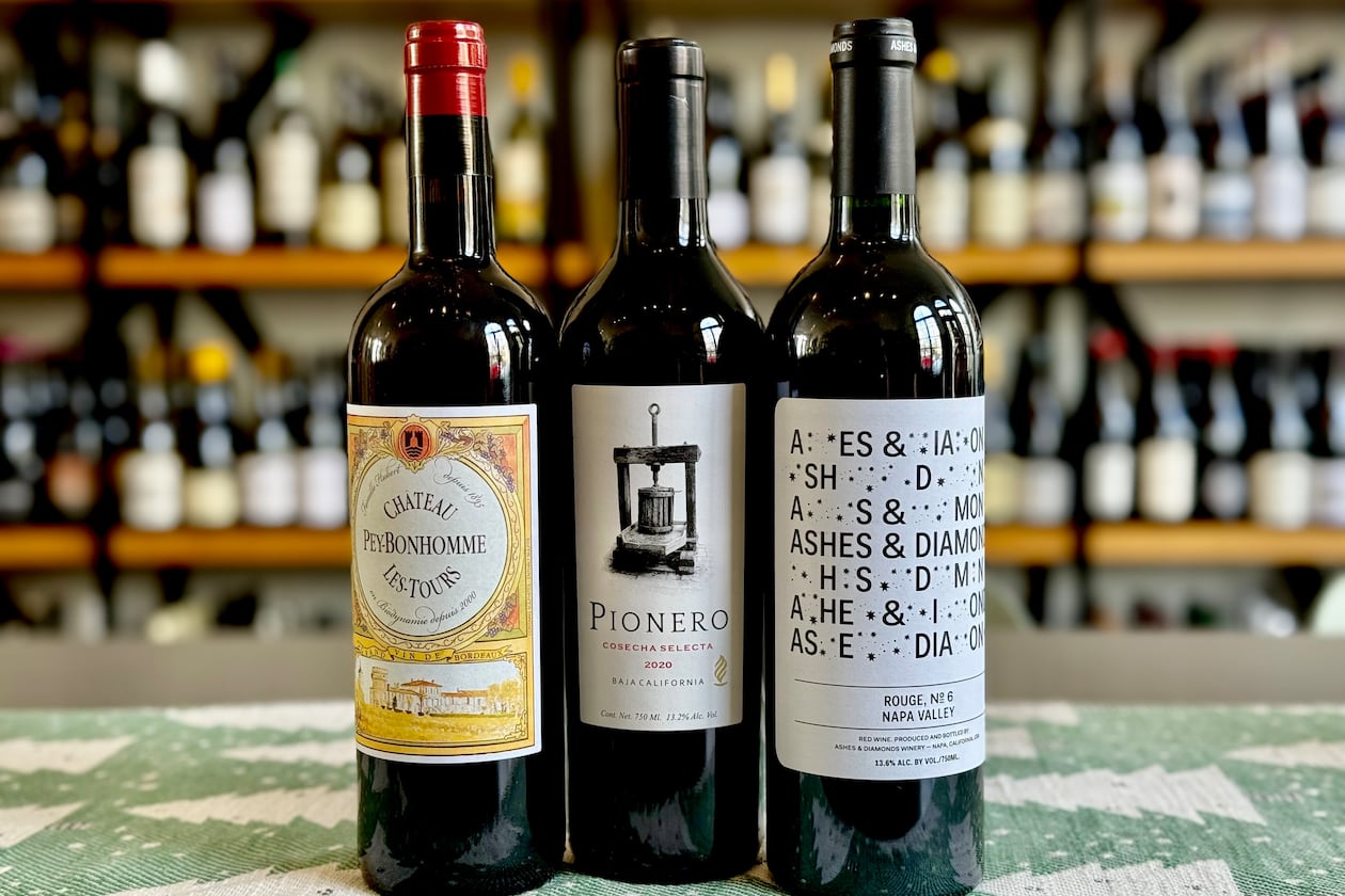 Red wine blend recommendations for the holiday season. Château Peybonhomme Les Tours Côtes de Blaye Bordeaux (left), Pionero Cosecha Selecta (center) and Ashes & Diamonds Rouge No. 6 (right). (Krista Slater for the AJC)