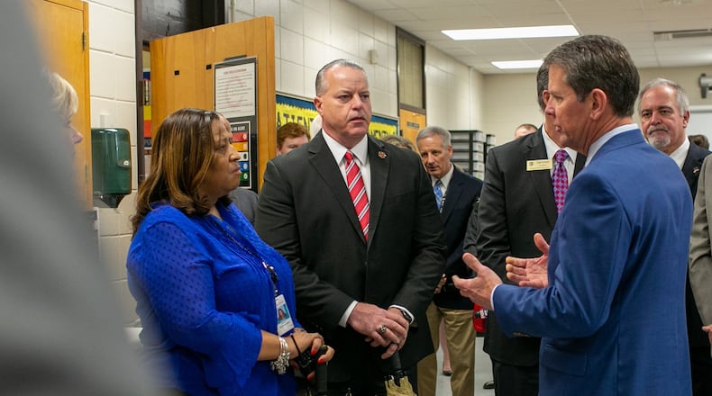 Gov. Brian Kemp speaks to McEachern High School Principal Regina Montgomery and Cobb County Superintendent Chris Ragsdale (center)  during a tour of McEachern High School in Powder Springs on Thursday, Feb. 13, 2020. REBECCA WRIGHT / FOR THE AJC