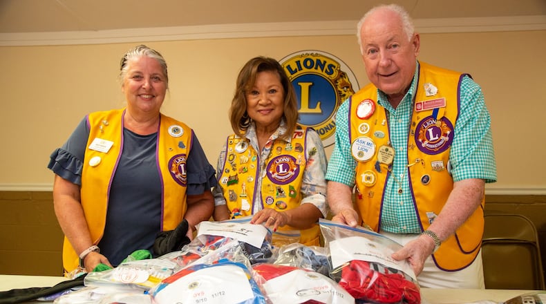 Missy Braden (from left), Doreen Stallworth, Richard Brown fill “PJ Packs” with new PJs, underwear and socks during a meeting of the Georgia Lions Club in Covington. Stallworth came up with a service project of giving “PJ Packs” to hospitalized children at Children’s Healthcare of Atlanta. (Photo by Phil Skinner)