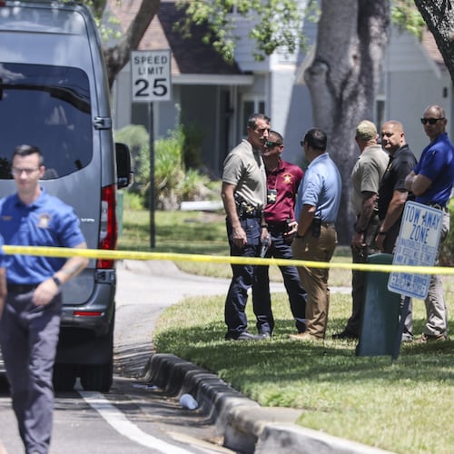 Detectives with the Hillsborough County Sheriff's Office join an investigation inside the Lake Forest subdivision of Tampa, Fla., on Friday, April 24, 2026, where authorities said a man was taken into custody after barricading himself inside a home, in connection to the search for two missing University of South Florida graduate students. (Douglas R. Clifford/Tampa Bay Times via AP)