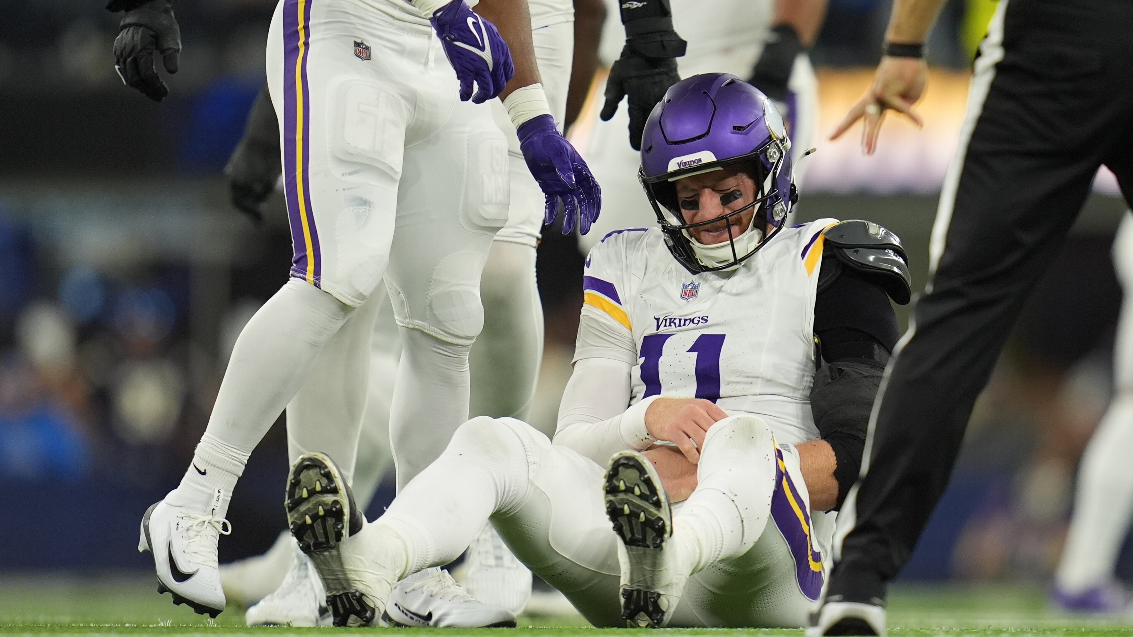 Minnesota Vikings quarterback Carson Wentz (11) sits on the ground after a hit during the second half of an NFL football game against the Los Angeles Chargers Thursday, Oct. 23, 2025, in Inglewood, Calif. (AP Photo/Gregory Bull)