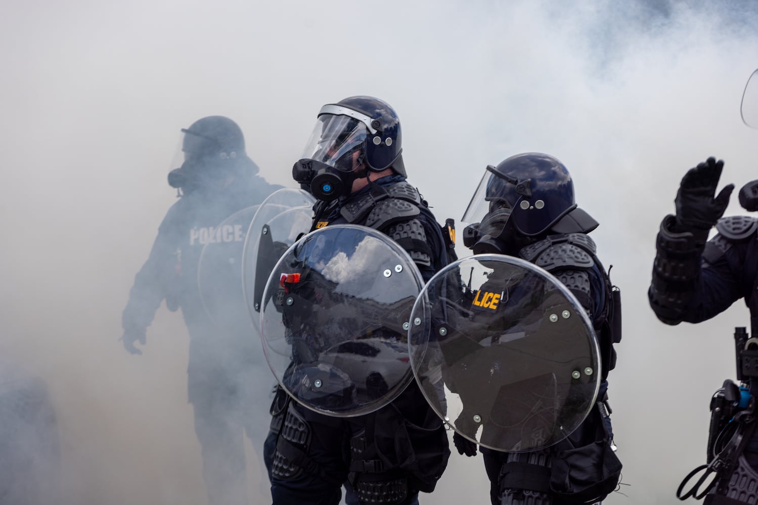 Police walk through tear gas during a protest on ICE raids and deportation arrests on Chamblee Tucker Road in Atlanta on Saturday, June 14, 2025. (Arvin Temkar / AJC)