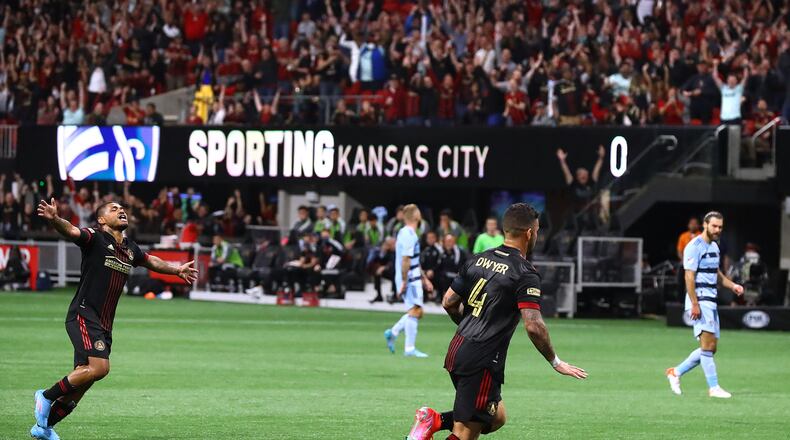 Atlanta United's Josef Martinez runs to celebrate with Dom Dwyer (right) after Dwyer scored a goal for a 2-0 lead over Sporting KC in an MLS match Sunday in Atlanta. Atlanta United won its home opener 3-1. (Curtis Compton / Curtis.Compton@ajc.com)