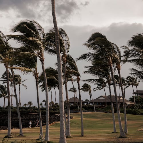 People walk along a path at Waikoloa Beach Resort as Tropical Storm Lala strengthened on the Big Island of Hawaii, Saturday, Aug. 15, 2026. (Stephen Lam/San Francisco Chronicle via AP)