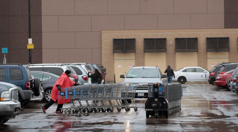 A worker collects shopping carts outside Walmart store on in Chicago, Illinois.