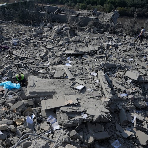 A rescue worker, left, searches for victims under the rubble of a home that was hit by an Israeli airstrike in Ansar village, southern Lebanon, Saturday, Aug. 15, 2026. (AP Photo/Mohammed Zaatari)