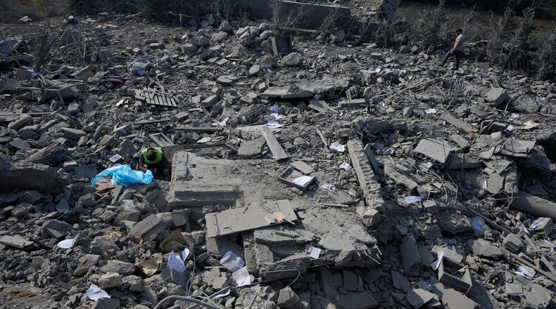 A rescue worker, left, searches for victims under the rubble of a home that was hit by an Israeli airstrike in Ansar village, southern Lebanon, Saturday, Aug. 15, 2026. (AP Photo/Mohammed Zaatari)