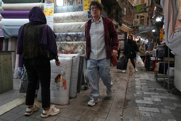 People walk through the old grand bazaar of Tehran, Iran, Saturday, April 5, 2025. (AP Photo/Vahid Salemi)