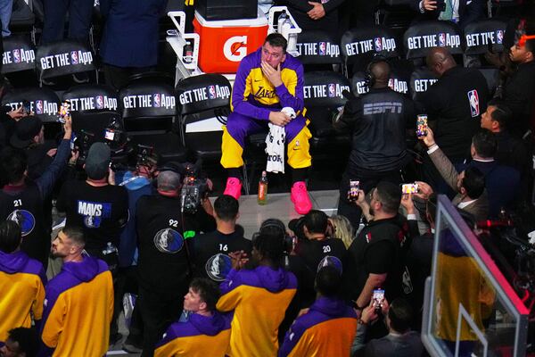 Los Angeles Lakers' Luka Doncic looks up at a large video board paying a tribute to the former Dallas Mavericks player before an NBA basketball game in Dallas, Wednesday, April 9, 2025. (AP Photo/Julio Cortez)