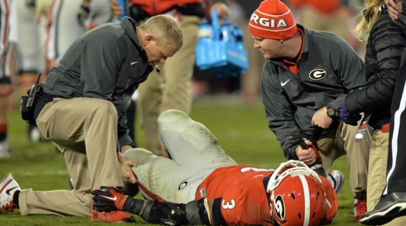 Ron Courson (L), attending to running back Todd Gurley in 2015, has brought cutting-edge technology into UGA’s sports medicine and training operation. (BRANT SANDERLIN/AJC file)