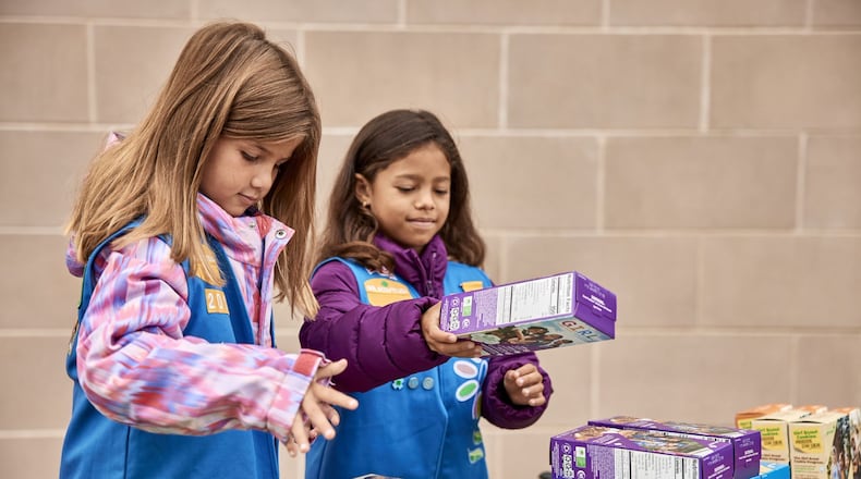 A pair of Girl Scouts from Cherokee County hawk baked goods at a booth sale, including the in-demand Adventureful cookie. Booth sales of Girl Scout Cookies began this month. Photo: Girl Scouts