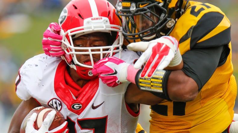 Nick Chubb #27 of the Georgia Bulldogs is wrapped up by Ian Simon #21 of the Missouri Tigers midway in the fourth quarter on October 11, 2014 at Faurot Field/Memorial Stadium in Columbia, Missouri. (Photo by Kyle Rivas/Getty Images)