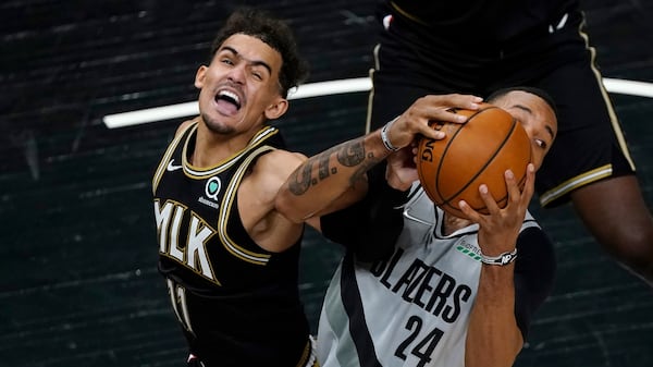 Hawks guard Trae Young (11) and Portland Trail Blazers forward Norman Powell (24) battle for a rebound in the second half Monday, May 3, 2021, in Atlanta. (John Bazemore/AP)