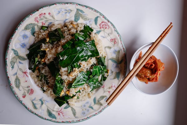 Collard Green Fried Rice, shown here with a side of kimchee, is one of the recipes featured in “Down South + East”, a new cookbook by Ron Hsu, executive chef of Lazy Betty. (Natrice Miller/AJC)