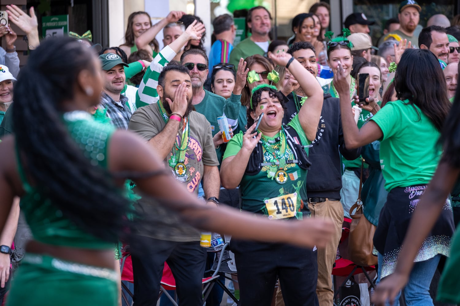The crowd in front of Fadó Irish Pub cheers as the Atlanta St. Patrick’s Parade makes its way down Peachtree Street on Saturday, March 14, 2026. (Ben Gray for the AJC)
