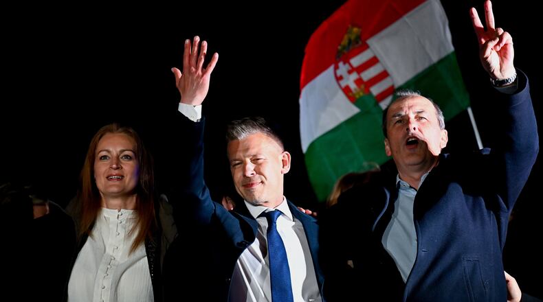 Peter Magyar, leader of the opposition Tisza party, center, celebrates with his party colleagues following the announcement of the partial results of the parliamentary election, in Budapest, Hungary, Sunday, April 12, 2026. (AP Photo/Denes Erdos)