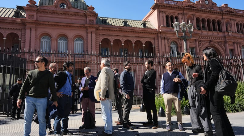 Journalists stand outside of the Casa Rosada government headquarters after President Javier Milei blocked their access, in Buenos Aires, Argentina, Thursday, April 23, 2026. (AP Photo/Rodrigo Abd)