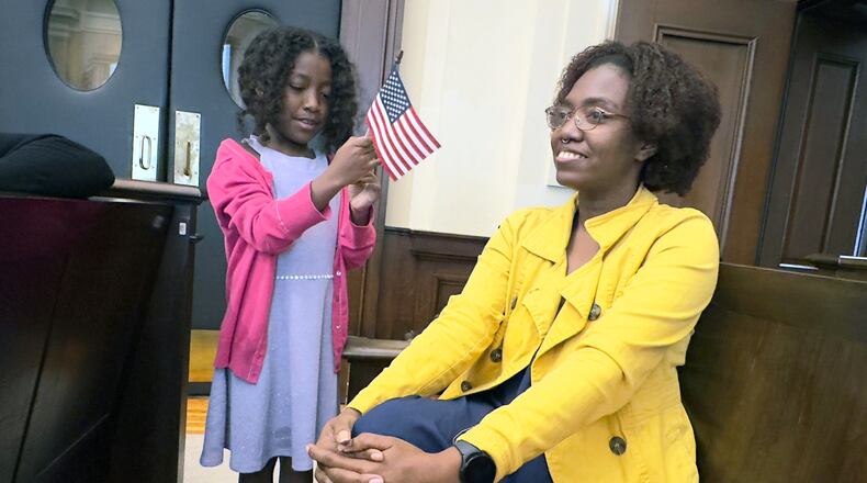 Zara Montano, left, and her mother, Karen Caicedo, at the federal courthouse in Macon on Wednesday where Caicedo, a native of Colombia, was sworn in as a U.S. citizen. She was among 22 people from 15 countries who took the Oath of Allegiance.