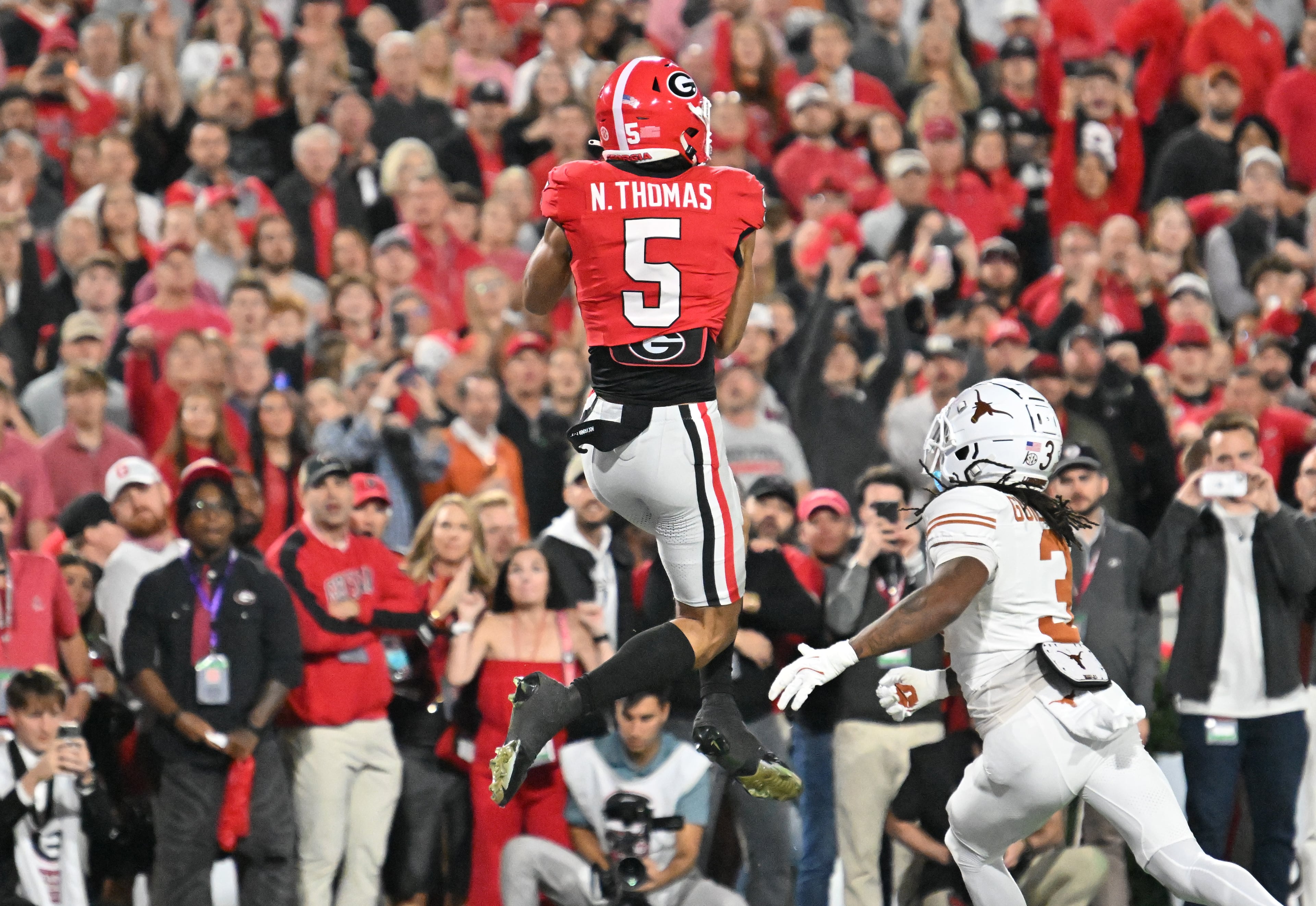Georgia wide receiver Noah Thomas (5) makes a touchdown catch over Texas defensive back Jaylon Guilbeau (3) during the first half in an NCAA football game at Sanford Stadium, Saturday, November 15, 2025, in Athens. (Hyosub Shin / AJC)