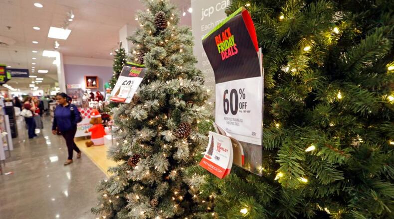 A shopper walks past a display of artificial Christmas trees at a JCPenney store Friday, Nov. 24, 2017, in Seattle. Black Friday has morphed from a single day when people got up early to score doorbusters into a whole season of deals, so shoppers may feel less need to be out. (AP Photo/Elaine Thompson)