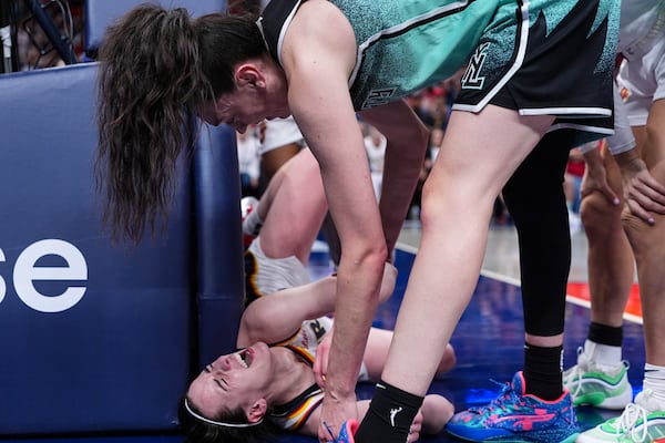 New York Liberty forward Breanna Stewart, top, checks on Indiana Fever guard Caitlin Clark (22) after contract on a shot in the second half of a WNBA basketball game in Indianapolis, Saturday, May 24, 2025. (AP Photo/Michael Conroy)