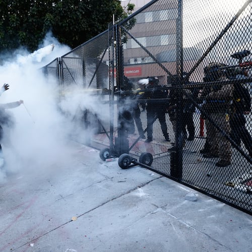 Protestors face off against police firing tear gas outside the Metropolitan Detention Center in downtown Los Angeles during a "No Kings" rally Saturday, March 28, 2026. (AP Photo/Jill Connelly)