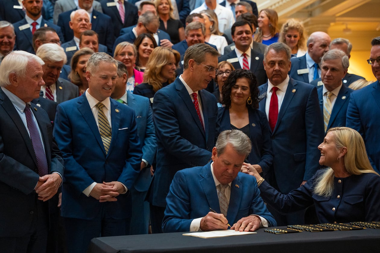 Gov. Brian Kemp signs SB 68 and SB 69 into law alongside first lady Marty Kemp during a press conference at the Georgia Capitol. (Olivia Bowdoin for the AJC 2025)