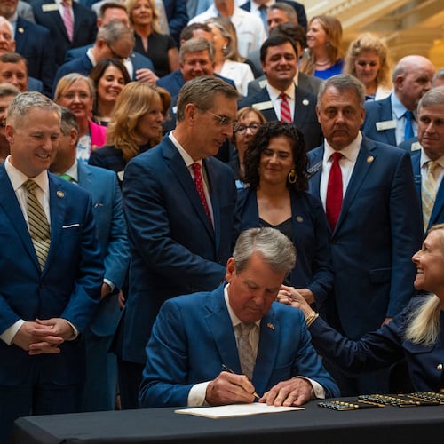 Gov. Brian Kemp signs SB 68 and SB 69 into law alongside first lady Marty Kemp during a press conference at the Georgia Capitol. (Olivia Bowdoin for the AJC 2025)