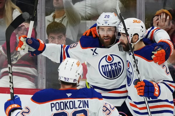Edmonton Oilers' Leon Draisaitl (29) celebrates after his winning goal against the Florida Panthers with Evan Bouchard (2) during the first overtime period in Game 4 of the NHL hockey Stanley Cup Final in Sunrise, Fla., Thursday, June 12, 2025. (Nathan Denette/The Canadian Press via AP)