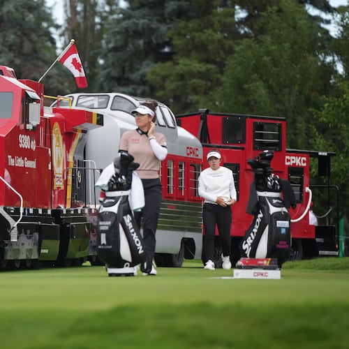 Miyu Yamashita, back right, of Japan, walks past a mini CPKC train as she arrives at the first tee behind Hannah Green, of Australia, during the first round at the LPGA Canadian Women's Open golf tournament in Edmonton, Alberta, Thursday, Aug. 20, 2026. (Darryl Dyck/The Canadian Press via AP)