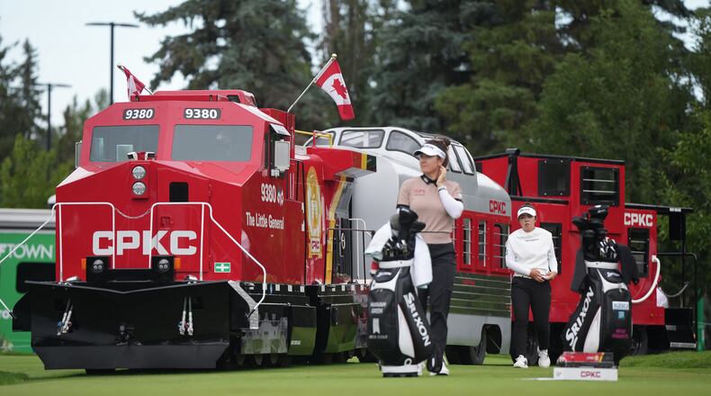 Miyu Yamashita, back right, of Japan, walks past a mini CPKC train as she arrives at the first tee behind Hannah Green, of Australia, during the first round at the LPGA Canadian Women's Open golf tournament in Edmonton, Alberta, Thursday, Aug. 20, 2026. (Darryl Dyck/The Canadian Press via AP)