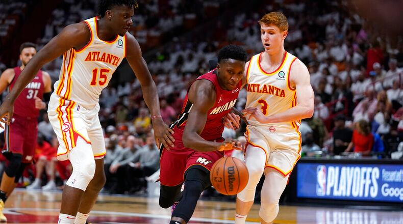 Miami Heat guard Victor Oladipo, center, drives to the basket against Atlanta Hawks center Clint Capela (15) and guard Kevin Huerter (3) during the first half of Game 5 of an NBA basketball first-round playoff series, Tuesday, April 26, 2022, in Miami. (AP Photo/Wilfredo Lee)
