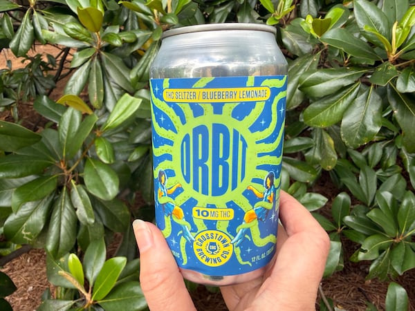 A female hand holds the bottom of a can of Orbit blueberry lemonade for the camera shot.
