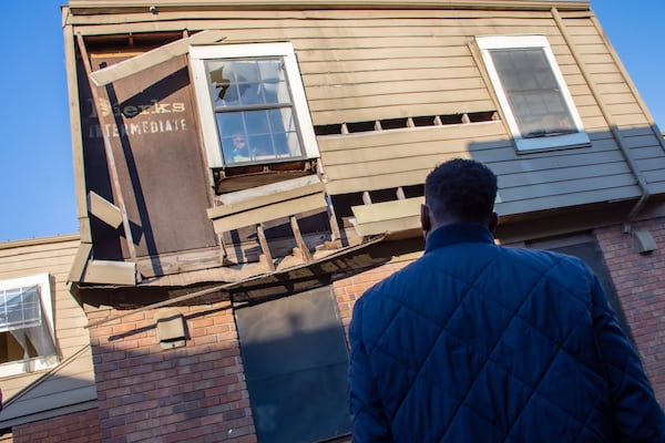 Atlanta Mayor Andre Dickens stares back at a child looking out of a near-collapsing window as he reviews the conditions at the Forest Cove Apartments in the Thomasville Heights community on Saturday, Feb. 12, 2022. (City of Atlanta)