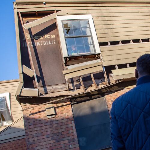 A child stares out of a near-collapsing window at Atlanta Mayor Andre Dickens as he reviews conditions at the Forest Cove Apartments in the Thomasville Heights community. (Courtesy of City of Atlanta 2022)