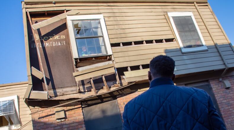Atlanta Mayor Andre Dickens stares back at a child looking out of a near-collapsing window as he reviews the conditions at the Forest Cove Apartments in the Thomasville Heights community Saturday, Feb. 12, 2022. (Courtesy of city of Atlanta)
