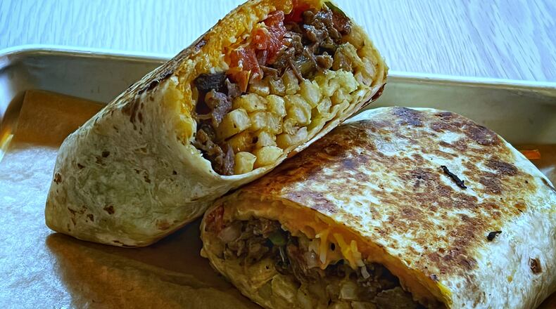 The surfer burrito from Muchacho somehow manages to keep its well-balanced and flavorful fillings inside the tortilla. Henri Hollis/henri.hollis@ajc.com