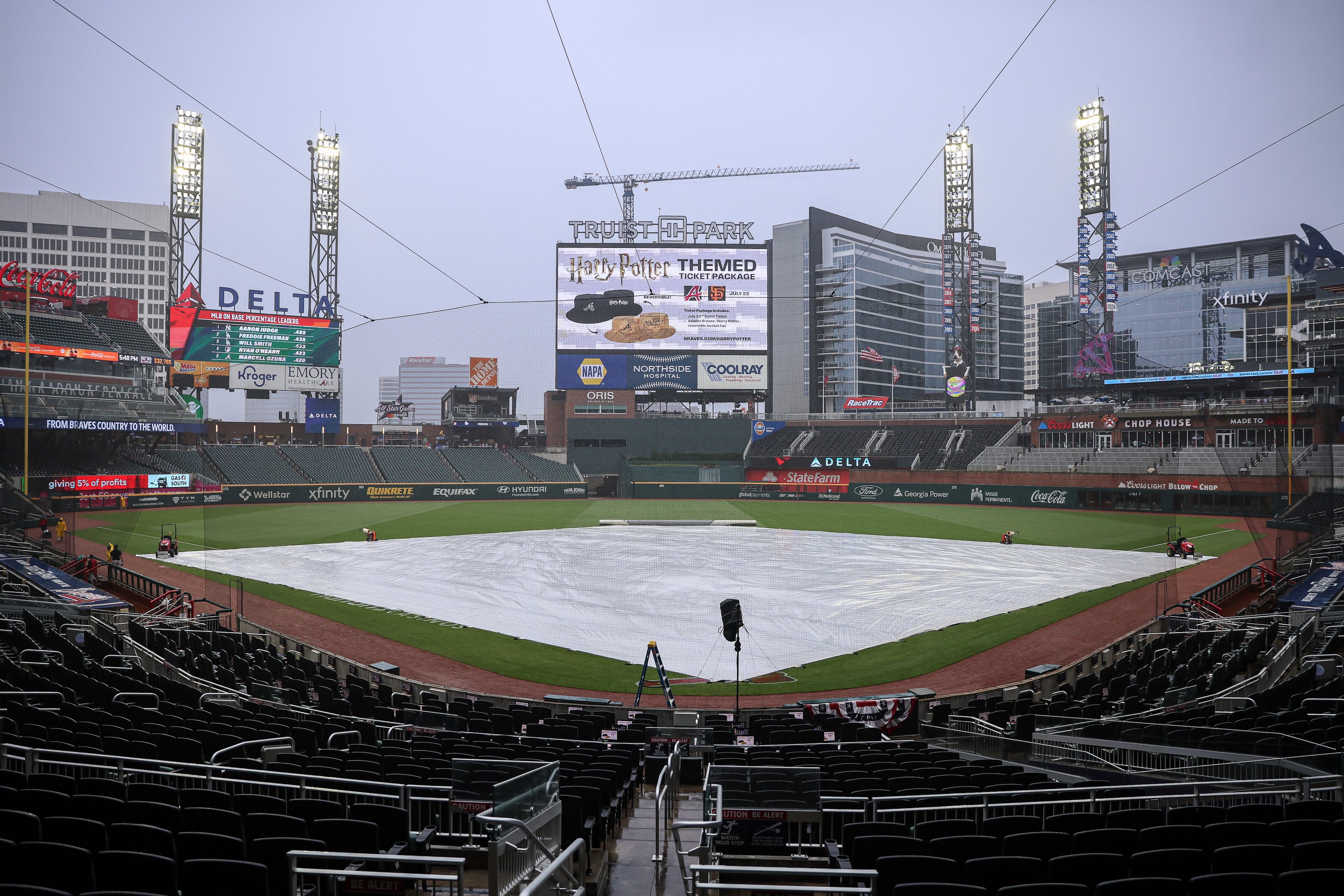 A tarp is covering the infield as rain is falling, delaying the start of a baseball game between the Arizona Diamondbacks and Atlanta Braves, Wednesday, June 4, 2025, in Atlanta. (AP Photo/Colin Hubbard)