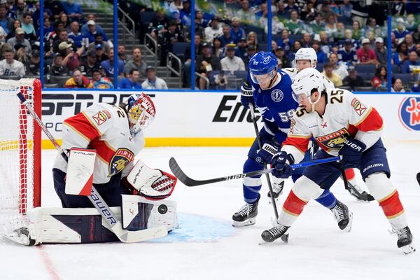 Florida Panthers goaltender Sergei Bobrovsky (72) stops a shot as right wing Mackie Samoskevich (25) keeps Tampa Bay Lightning center Jake Guentzel (59) from a rebound during the second period in Game 2 of an NHL hockey Stanley Cup first-round playoff series, Thursday, April 24, 2025, in Tampa, Fla. (AP Photo/Chris O'Meara)