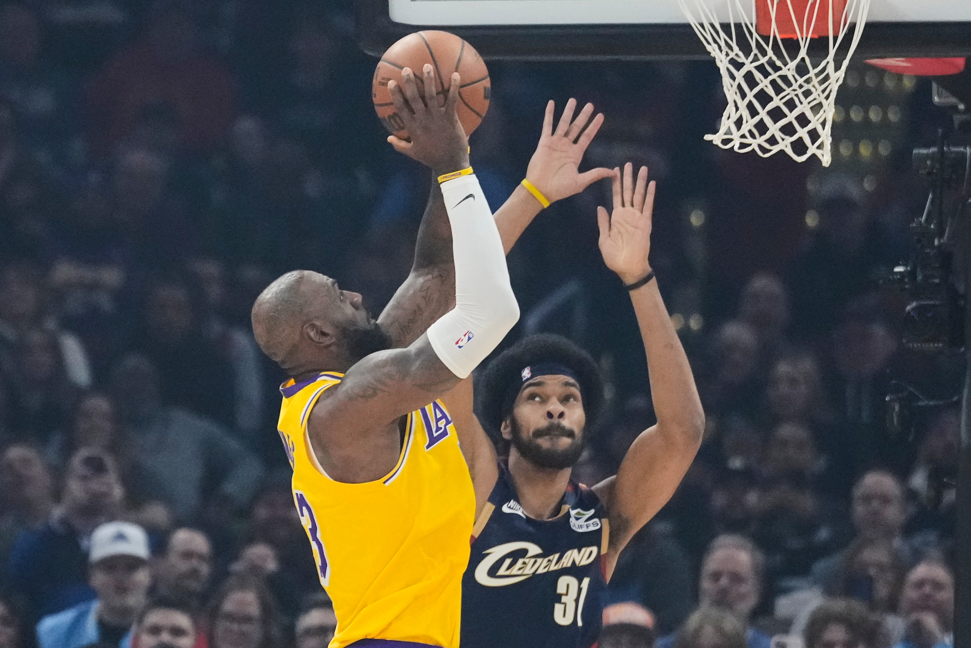 Los Angeles Lakers forward LeBron James left, shoots over Cleveland Cavaliers center Jarrett Allen (31) in the first half of an NBA basketball game in Cleveland, Wednesday, Jan. 28, 2026. (AP Photo/Sue Ogrocki)