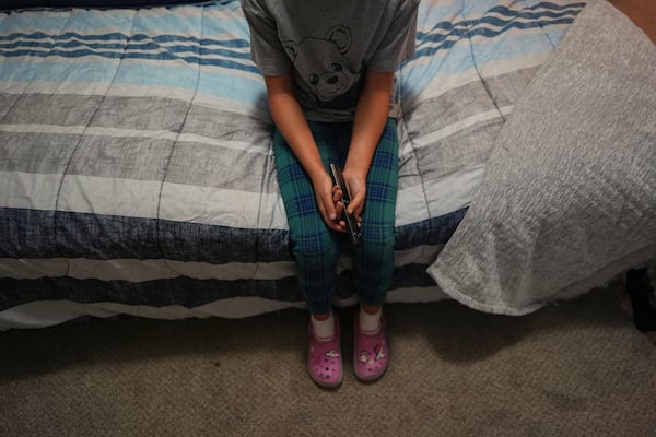 FILE - A 9-year-old girl with Temporary Protected Status, or TPS, who was born in Venezuela, but who fluently speaks only English and is in the gifted program at her school, watches TV in her family's apartment, April 5, 2025, in Doral, Fla. (AP Photo/Rebecca Blackwell, File)