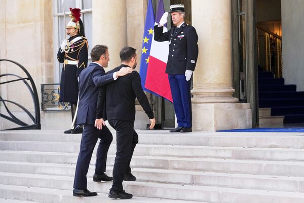 French President Emmanuel Macron, center left, walks with Ukraine's President Volodymyr Zelenskyy, center right, during arrivals for a summit on Ukraine at the Elysee Palace in Paris, Thursday, March 27, 2025 . (AP Photo/Thibault Camus)