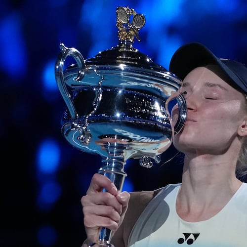Elena Rybakina of Kazakhstan kisses the Daphne Akhurst Memorial Cup after defeating Aryna Sabalenka of Belarus to win the women's singles final at the Australian Open tennis championship in Melbourne, Australia, Saturday, Jan. 31, 2026. (AP Photo/Aaron Favila)