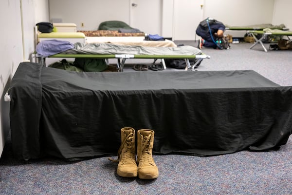 Boots sit next to a cot in one of the sleeping areas set up for the up to 5,000 soldiers who will be quartered in the GSA Regional Office Building for the Army's 250th Birthday celebration, Sunday, June 8, 2025, in Washington. (AP Photo/Kevin Wolf)