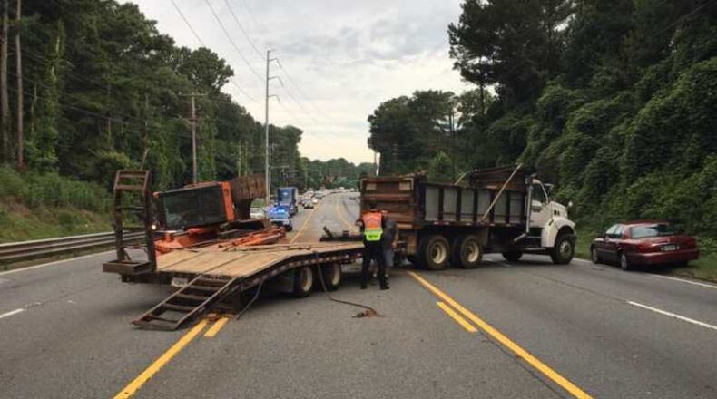 After an accident, a bulldozer fell off a truck, blocking lanes of traffic on a road in north Fulton County on Thursday.